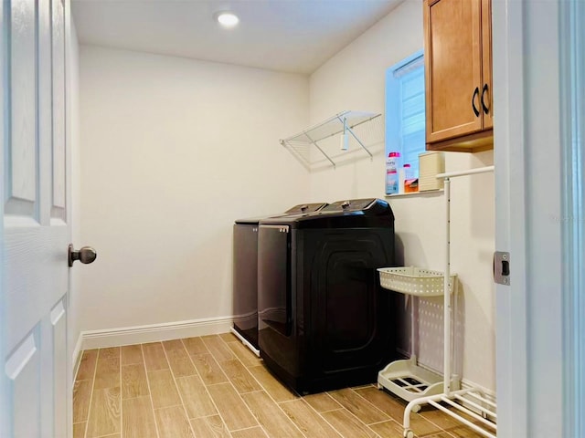 5019 Down Ct, Saint Cloud, FL 34772 - laundry area with cabinet space, light wood-style floors, baseboards, and separate washer and dryer