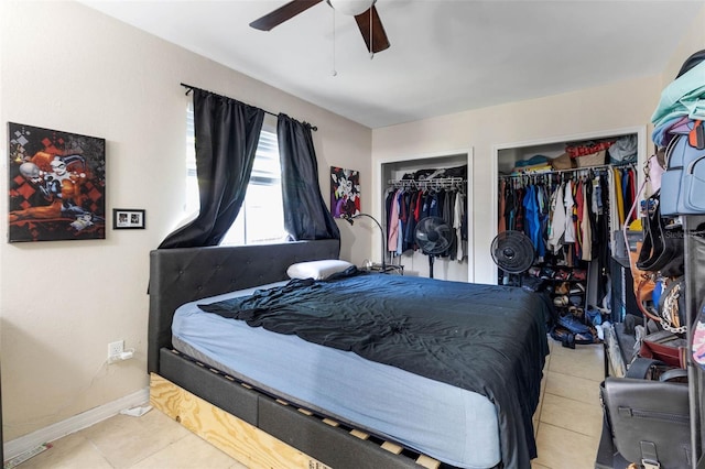 tiled bedroom featuring multiple closets, a ceiling fan, and baseboards