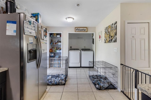 kitchen featuring separate washer and dryer, light tile patterned flooring, light countertops, and stainless steel fridge