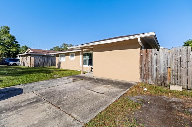 view of home's exterior featuring a yard, stucco siding, and fence