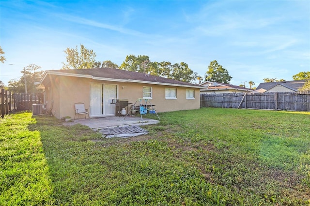 back of house featuring a patio, stucco siding, a fenced backyard, and a lawn