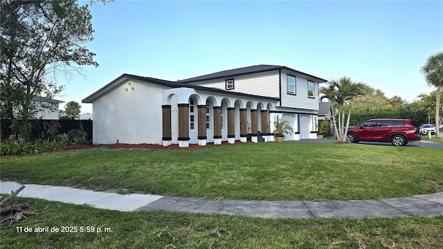 view of side of home featuring aphalt driveway, fence, an attached garage, a yard, and stucco siding