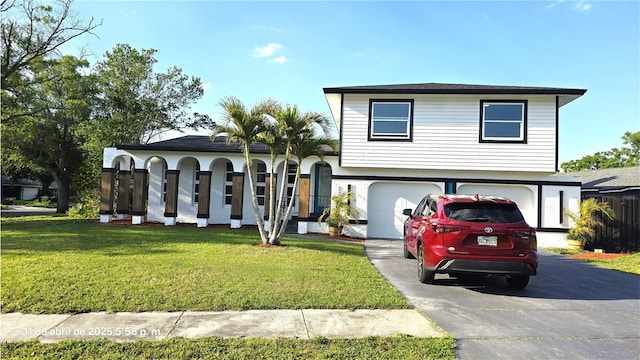 view of front of home with stucco siding, a front lawn, aphalt driveway, and an attached garage
