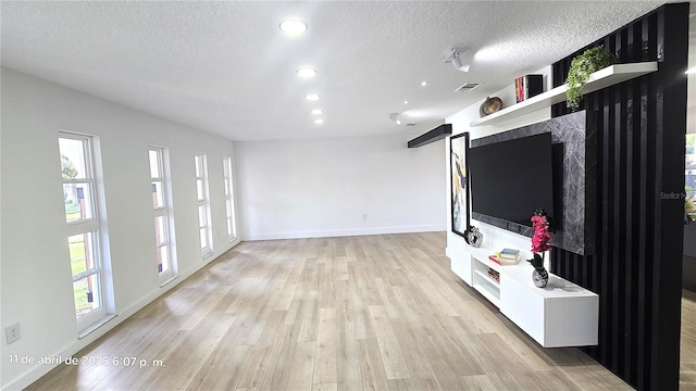 unfurnished living room with a textured ceiling, light wood-style flooring, baseboards, visible vents, and recessed lighting