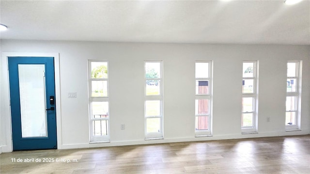 doorway to outside featuring wood finished floors and baseboards