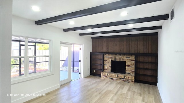 unfurnished living room featuring beam ceiling, light wood-type flooring, baseboards, recessed lighting, and a brick fireplace