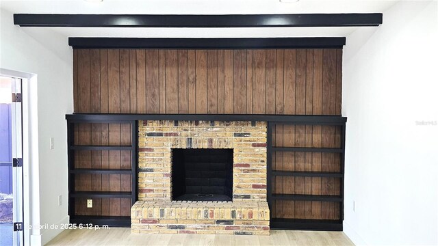 details with baseboards, a brick fireplace, and wood finished floors