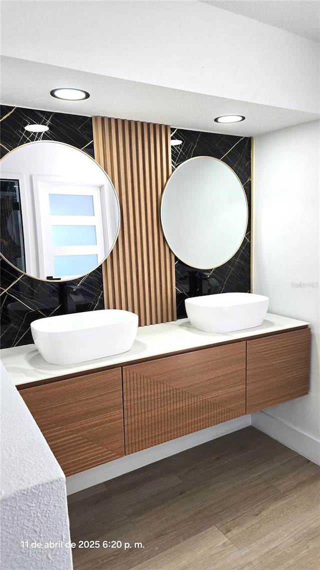 full bathroom with recessed lighting, baseboards, vanity, and wood finished floors