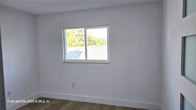 empty room featuring dark wood finished floors and baseboards