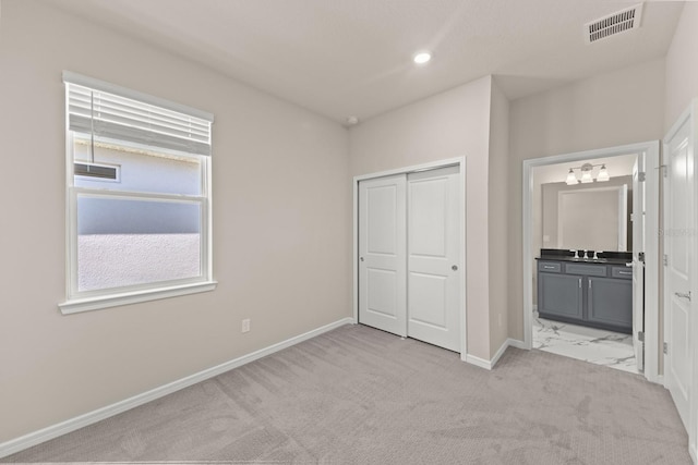 2019 Spring Shower Cir, Kissimmee, FL 34744 - unfurnished bedroom with a closet, baseboards, ensuite bath, carpet flooring, and visible vents