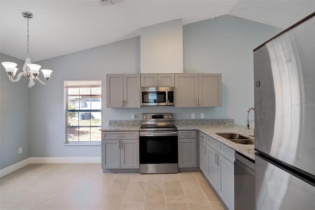kitchen featuring light stone counters, a sink, gray cabinetry, appliances with stainless steel finishes, and a notable chandelier