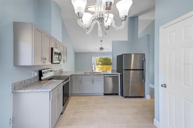 kitchen with an inviting chandelier, appliances with stainless steel finishes, gray cabinets, and a sink