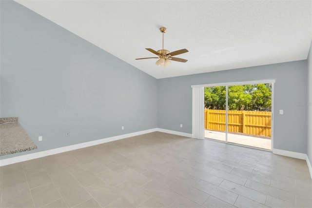 spare room featuring vaulted ceiling, baseboards, and ceiling fan