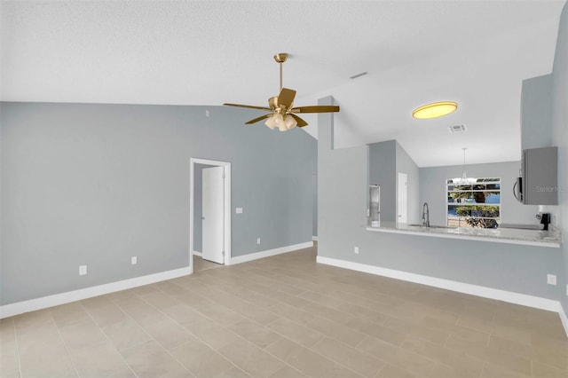 unfurnished living room with a sink, baseboards, visible vents, ceiling fan with notable chandelier, and lofted ceiling