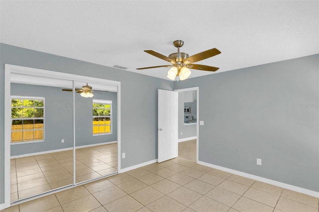 unfurnished bedroom with ceiling fan, tile patterned floors, and multiple windows