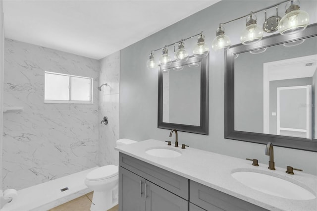 full bath featuring a shower stall, double vanity, toilet, and a sink