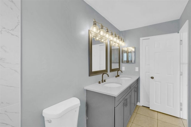 bathroom with tile patterned flooring, a sink, double vanity, and toilet