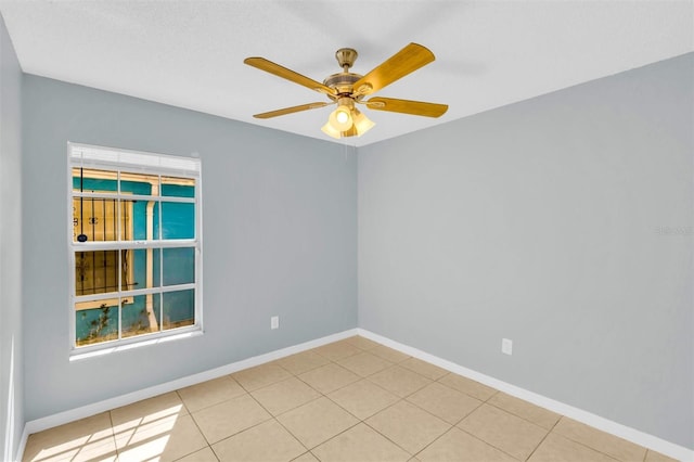 spare room with baseboards, tile patterned flooring, and ceiling fan
