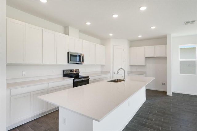 824 Lake Dell Rd, Dundee, FL 33838 - kitchen with electric range, stainless steel microwave, a sink, wood finish floors, and white cabinetry