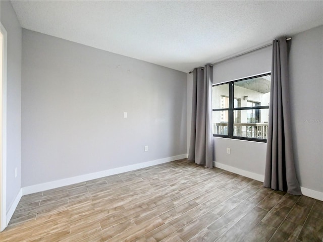 6165 Carrier Dr Unit 1603, Orlando, FL 32819 - unfurnished room with wood finished floors, baseboards, and a textured ceiling