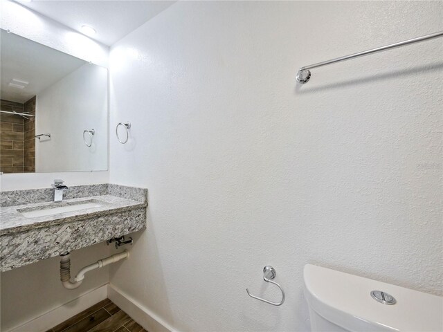 6165 Carrier Dr Unit 1603, Orlando, FL 32819 - bathroom featuring a sink, toilet, baseboards, and wood finished floors