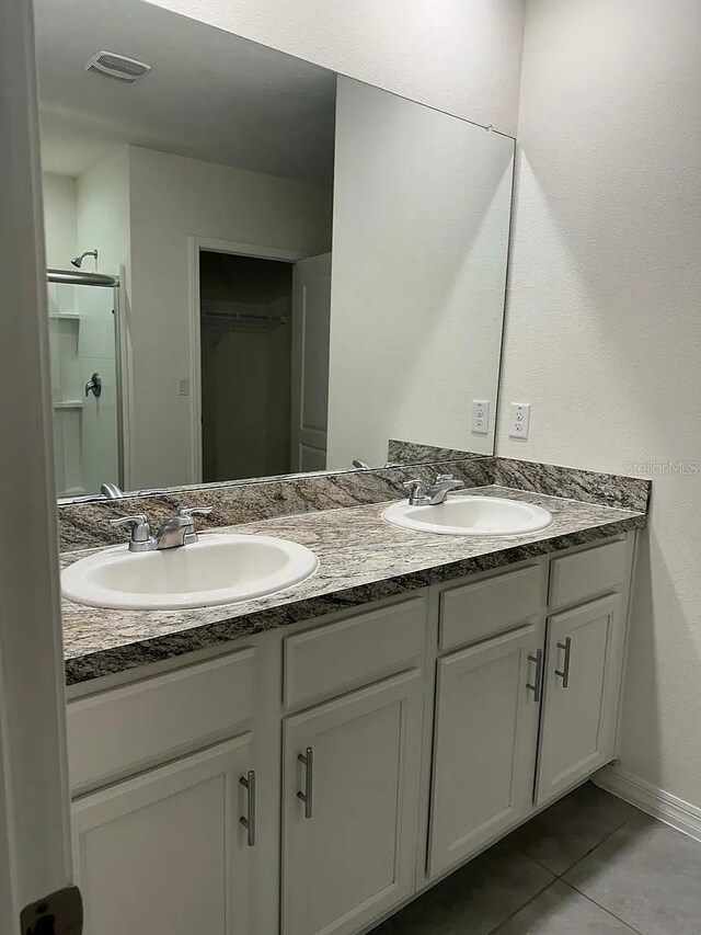 167 Eagleview Loop, Davenport, FL 33837 - full bath with tile patterned flooring, double vanity, a shower stall, and baseboards
