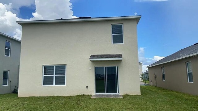 167 Eagleview Loop, Davenport, FL 33837 - rear view of property with stucco siding and a yard