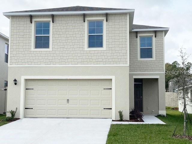 167 Eagleview Loop, Davenport, FL 33837 - view of front of property with driveway, stucco siding, an attached garage, and a front yard