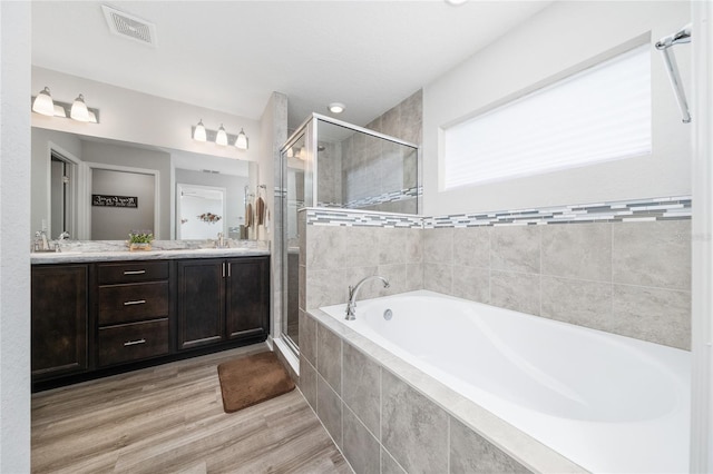 2059 Dexter St, Haines City, FL 33844 - bathroom with double vanity, visible vents, a sink, a garden tub, and a stall shower