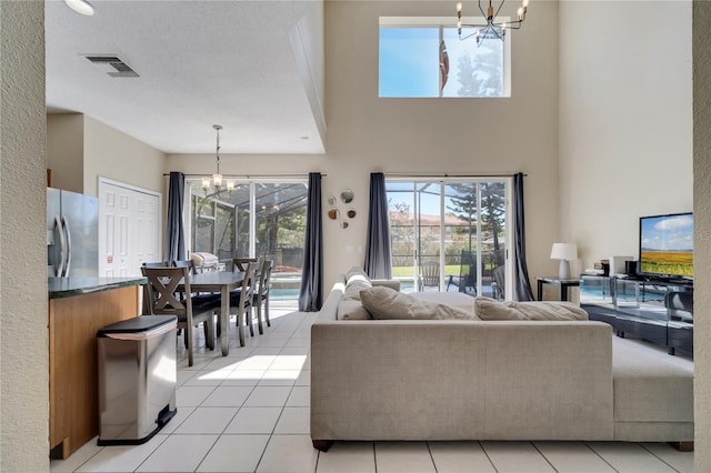 997 Lake Berkley Dr, Kissimmee, FL 34746 - living area with a towering ceiling, visible vents, a notable chandelier, and light tile patterned floors