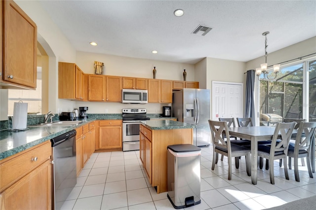 997 Lake Berkley Dr, Kissimmee, FL 34746 - kitchen featuring stainless steel appliances, visible vents, a sink, light tile patterned flooring, and a center island