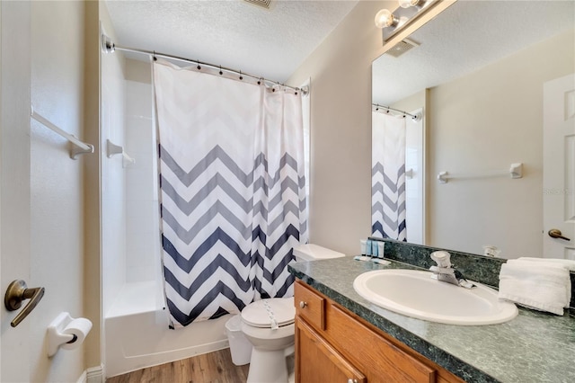997 Lake Berkley Dr, Kissimmee, FL 34746 - bathroom featuring wood finished floors, a textured ceiling, vanity, toilet, and visible vents