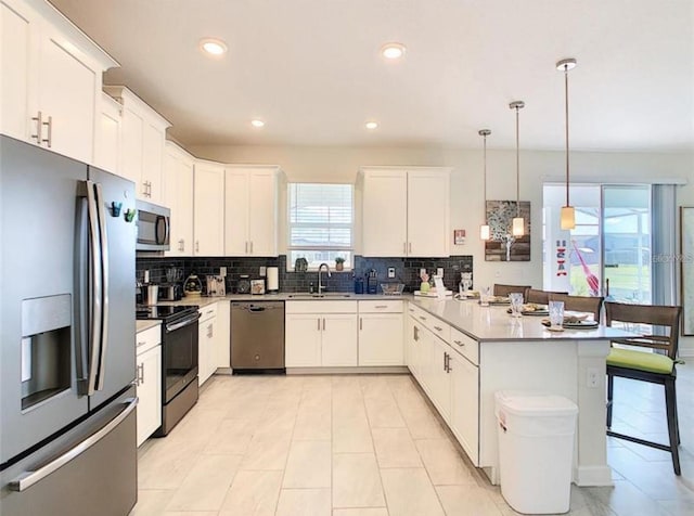 345 Ocean Course Ave, Davenport, FL 33896 - kitchen featuring stainless steel appliances, a peninsula, a sink, and backsplash