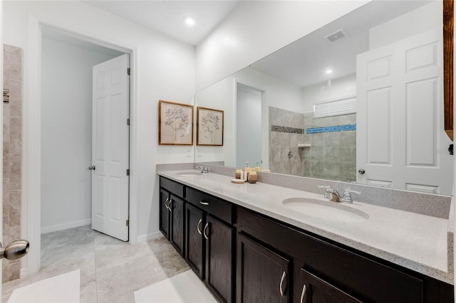 bathroom with double vanity, visible vents, a walk in shower, and a sink