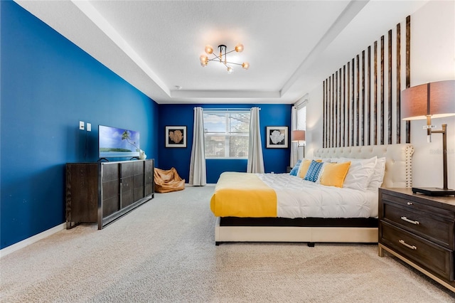 bedroom with baseboards, a tray ceiling, and carpet