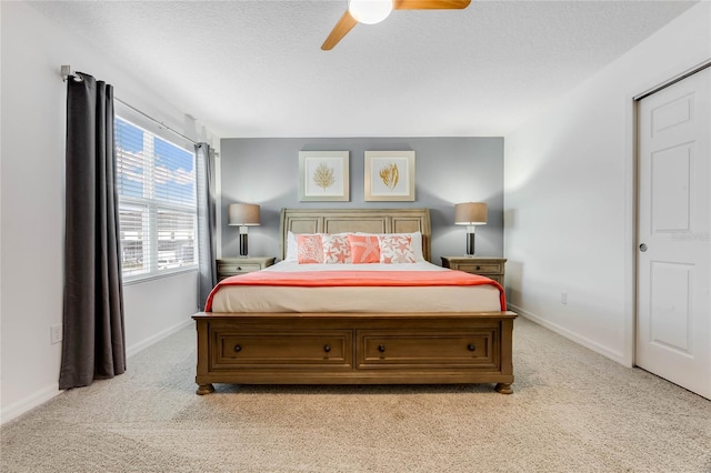 bedroom featuring carpet floors, a textured ceiling, baseboards, and ceiling fan