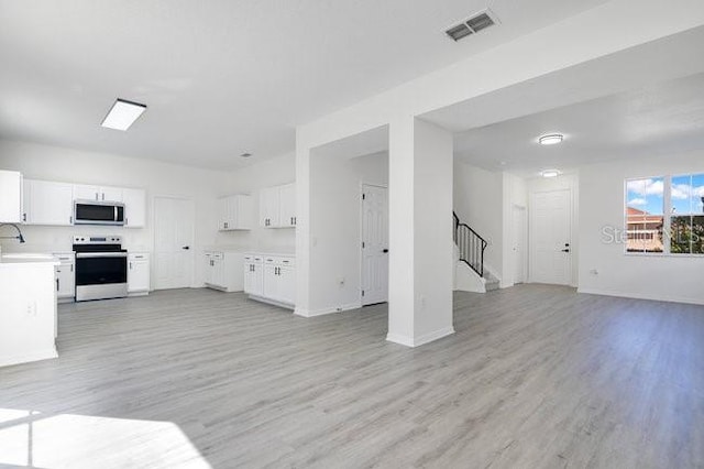 227 Sand Ridge Dr, Davenport, FL 33896 - kitchen with light wood-style floors, visible vents, appliances with stainless steel finishes, and open floor plan