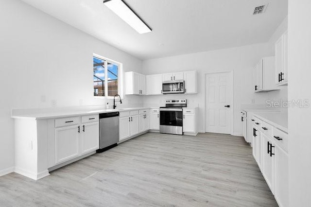 227 Sand Ridge Dr, Davenport, FL 33896 - kitchen with visible vents, a sink, light wood-type flooring, baseboards, and appliances with stainless steel finishes