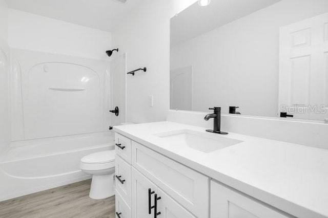 227 Sand Ridge Dr, Davenport, FL 33896 - full bath featuring wood finished floors, shower / bathtub combination, vanity, and toilet
