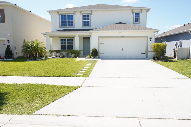 9016 Pyrus St, Kissimmee, FL 34747 - traditional-style house with stucco siding, a garage, driveway, and a front lawn