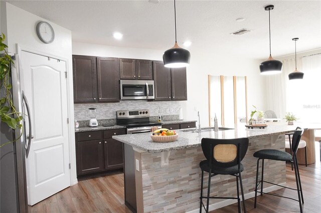 9016 Pyrus St, Kissimmee, FL 34747 - kitchen with stainless steel appliances, a sink, light wood-type flooring, backsplash, and recessed lighting