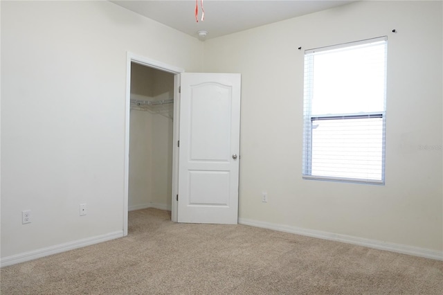 9016 Pyrus St, Kissimmee, FL 34747 - unfurnished bedroom with light carpet, a walk in closet, a closet, and baseboards