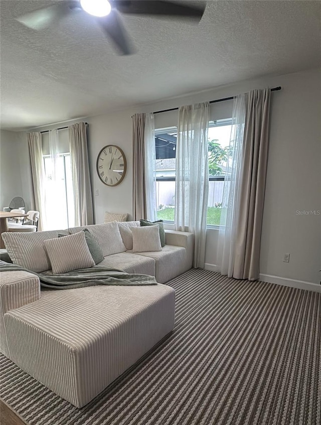 9016 Pyrus St, Kissimmee, FL 34747 - carpeted living room featuring a ceiling fan, a textured ceiling, and baseboards