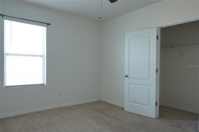 9016 Pyrus St, Kissimmee, FL 34747 - unfurnished bedroom with light colored carpet, multiple windows, and a closet