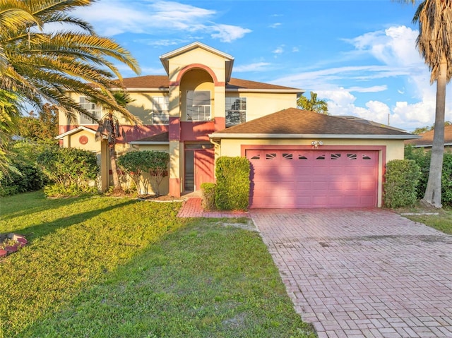 mediterranean / spanish-style house with a garage, a front lawn, stucco siding, and decorative driveway