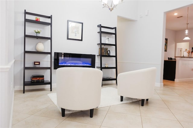 interior space featuring a glass covered fireplace, baseboards, tile patterned flooring, and recessed lighting