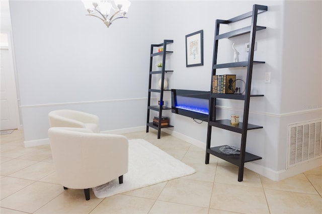 living area with baseboards, a chandelier, and visible vents