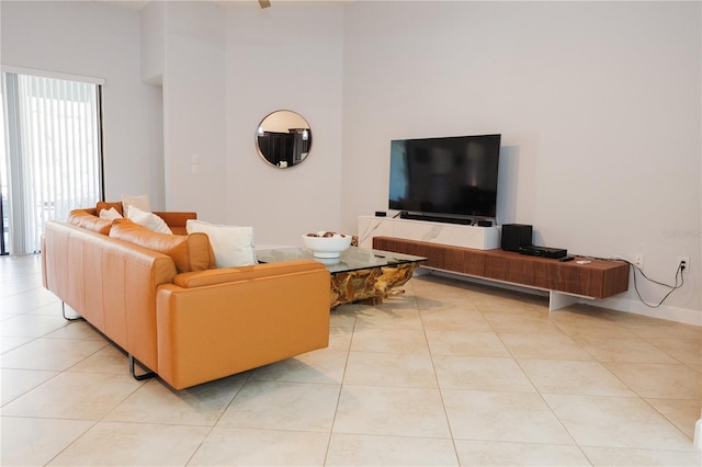 living area with a high ceiling and light tile patterned floors