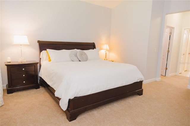 bedroom featuring baseboards and light colored carpet