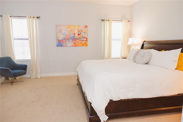 bedroom with baseboards, multiple windows, and carpet flooring